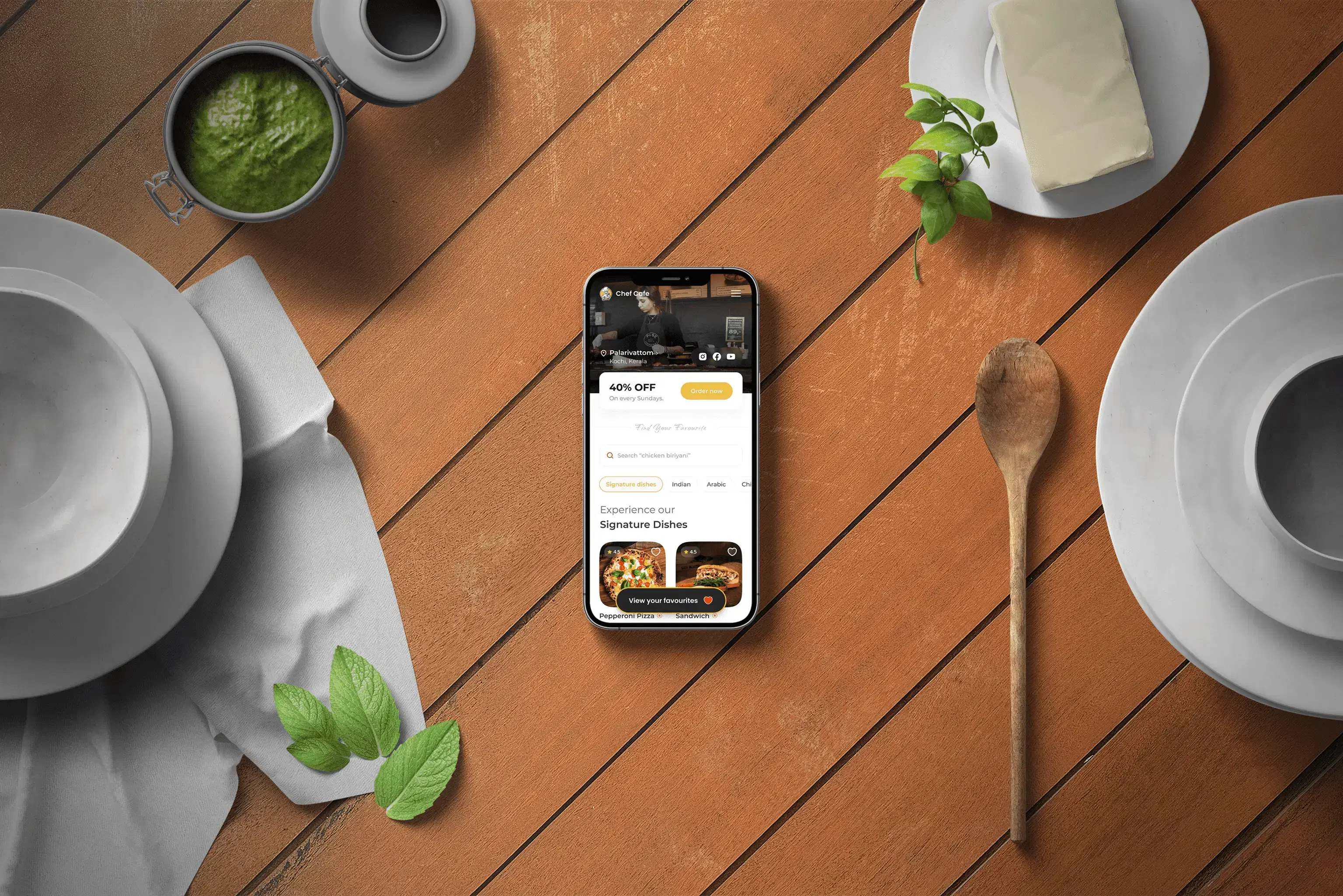 Foodee digital menu open on a phone, resting on a wooden table beside cafe ingredients